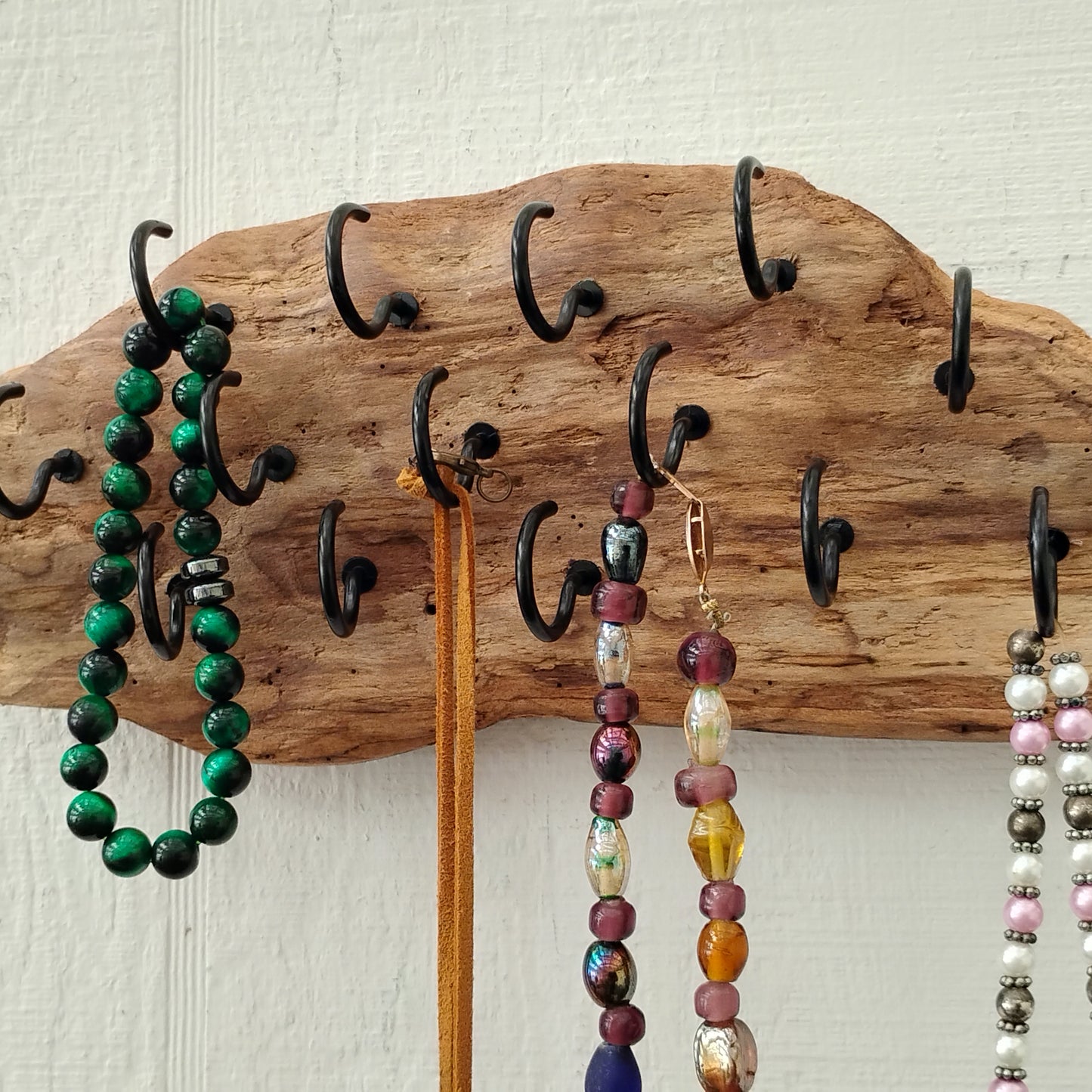 This wall mounted driftwood necklace display and organizer measures approximately 11 x 4 inches and has 15 1 inch black hooks and two saw tooth hangers to the back for added stability and balance when all hooks are used.