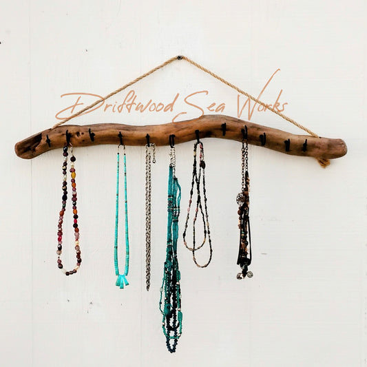 This bohemian inspired driftwood necklace hook and display measures approximately 24 x 2 inches. It was made with a natural piece of driftwood. I cleaned it up and sanded it then added 12 1 inch black hooks allowing space to display many of your favorite pieces. It hangs on the wall with a jute hanger.