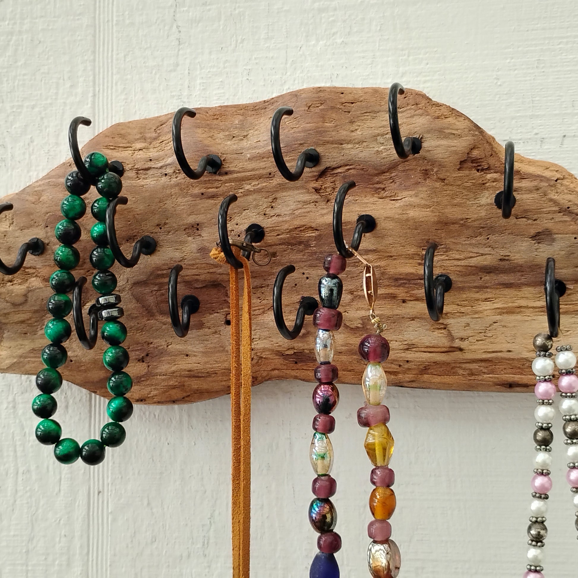This wall mounted driftwood necklace display and organizer measures approximately 11 x 4 inches and has 15 1 inch black hooks and two saw tooth hangers to the back for added stability and balance when all hooks are used.