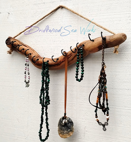 This driftwood necklace organizer measures approximately 18 inches long and 2 inches wide. The color of the driftwood is natural yellowish brown. I have added 12 black 1 inch hooks to this one and jute rope for hanging on the wall. This necklace display has been varnished to protect the wood and bring out the awesome natural colors seen in this display.